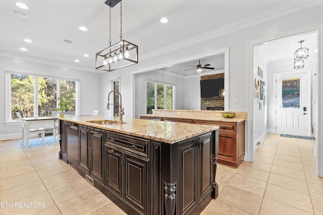 kitchen featuring a kitchen island with sink, ceiling fan, ornamental molding, pendant lighting, and sink