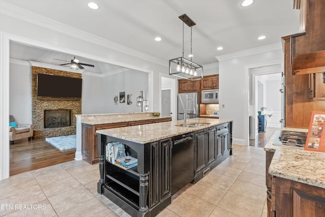 kitchen with light stone countertops, pendant lighting, stainless steel appliances, a center island with sink, and light tile patterned floors