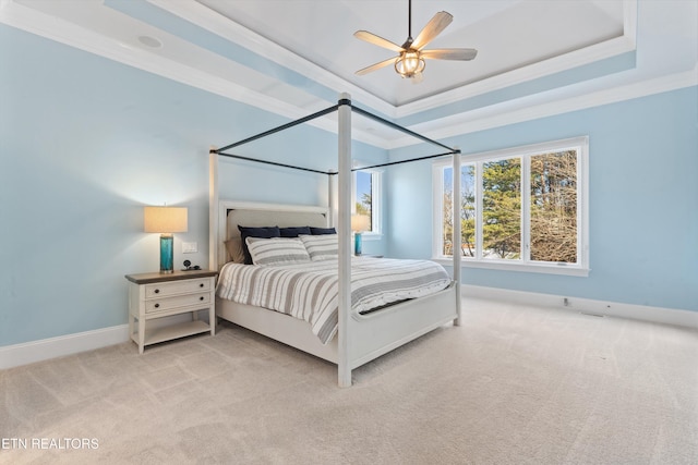 carpeted bedroom featuring ceiling fan, a tray ceiling, and crown molding