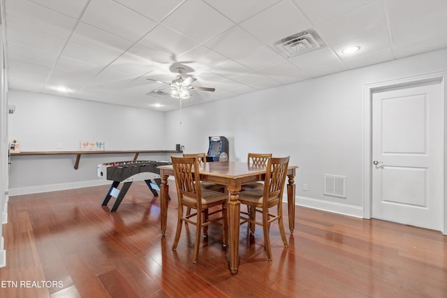 dining space featuring ceiling fan, a paneled ceiling, and hardwood / wood-style floors