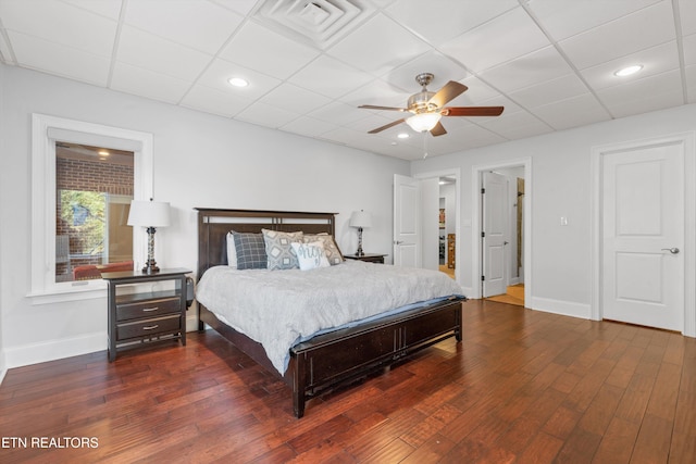 bedroom featuring a paneled ceiling, dark hardwood / wood-style flooring, and ceiling fan