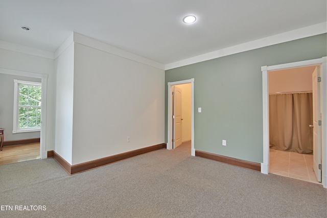 empty room with light colored carpet and ornamental molding