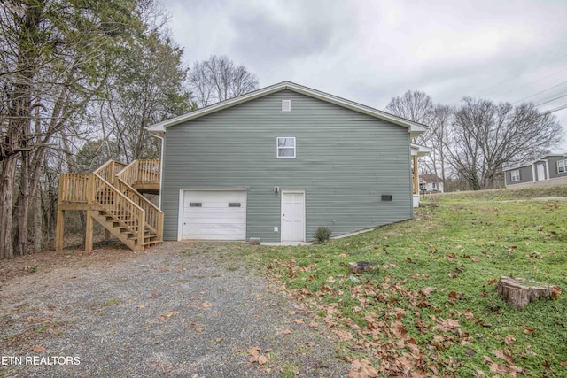 view of property exterior featuring a wooden deck, a yard, and a garage