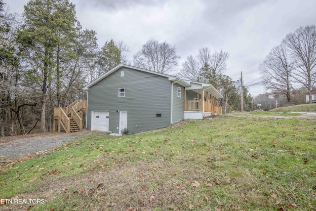 view of home's exterior with a yard, a garage, and a sunroom