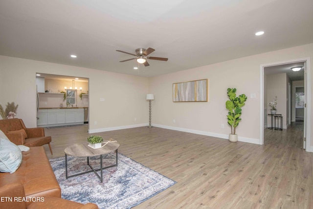 living room with ceiling fan and light wood-type flooring