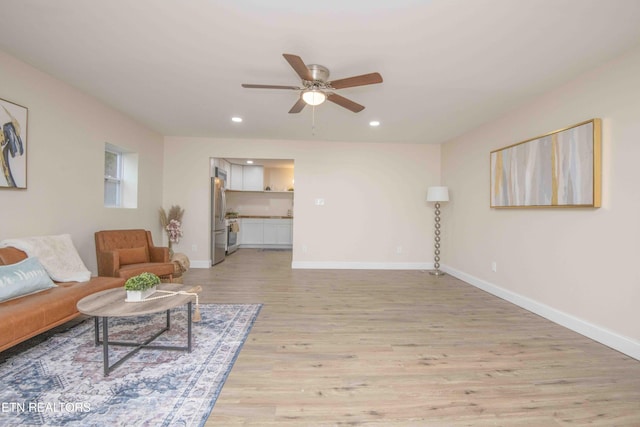 living room featuring ceiling fan and light hardwood / wood-style floors