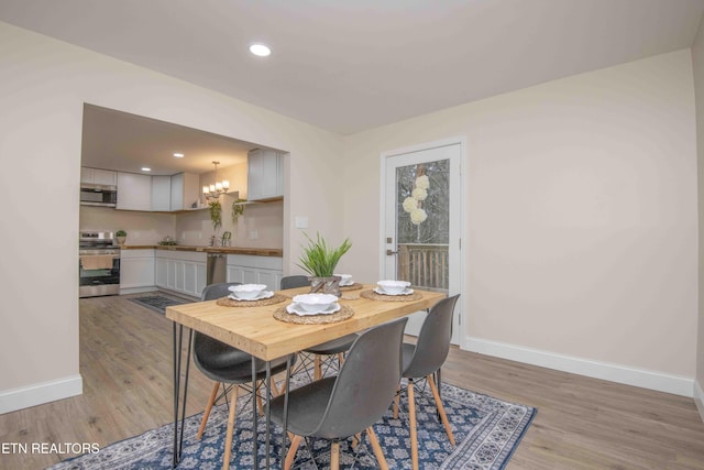 dining area featuring a chandelier and light wood-type flooring