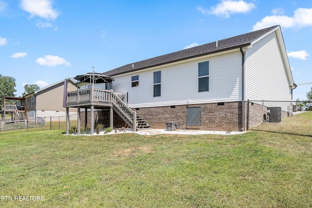 back of property featuring a lawn, cooling unit, and a wooden deck