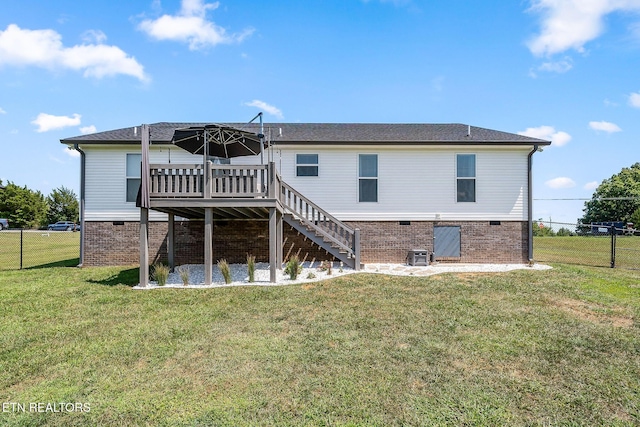 back of property featuring a yard and a wooden deck