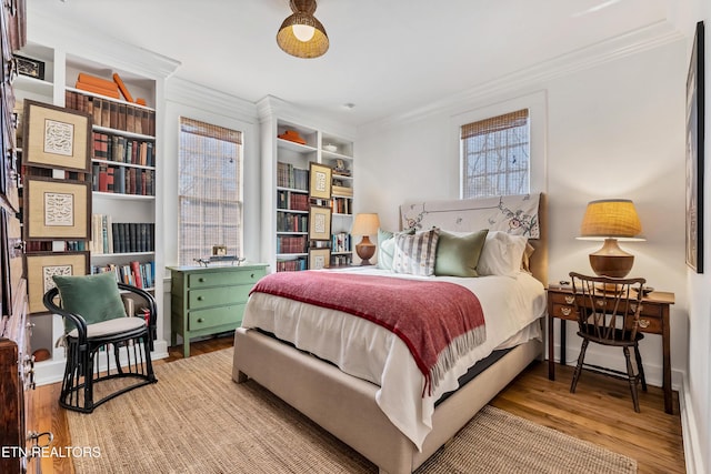 bedroom featuring light wood-type flooring and crown molding