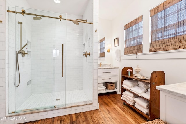 bathroom featuring vanity, hardwood / wood-style flooring, and a shower with shower door