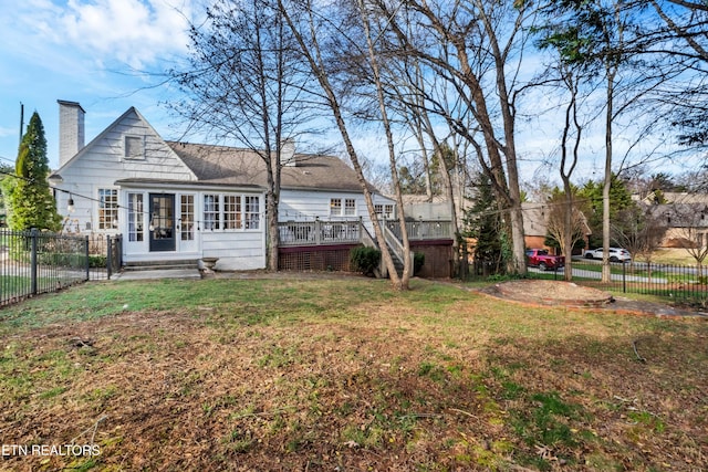 rear view of property featuring a yard and a deck