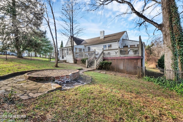 rear view of house featuring a deck and a yard