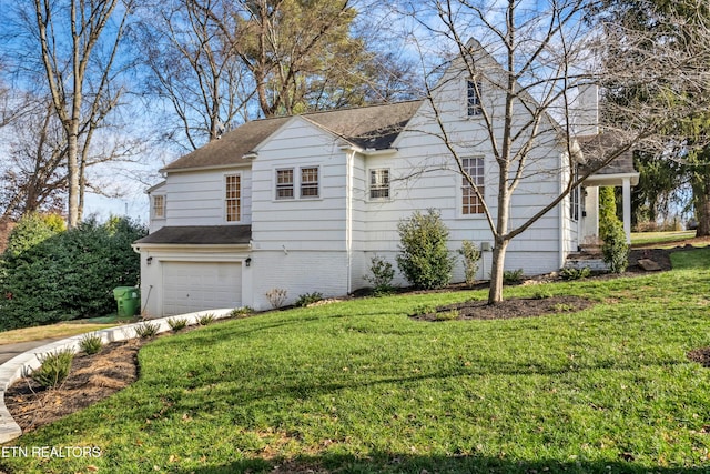 view of side of home with a yard and a garage