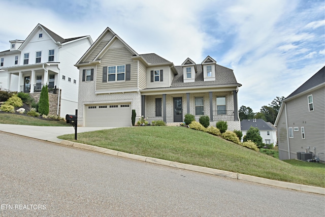 view of front facade featuring a porch, a garage, a front yard, and central air condition unit