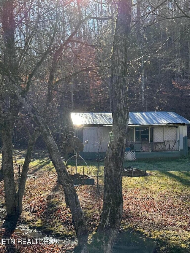 view of side of property with a yard and covered porch