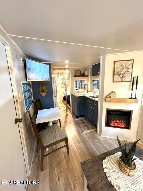 living area with light wood-type flooring and sink