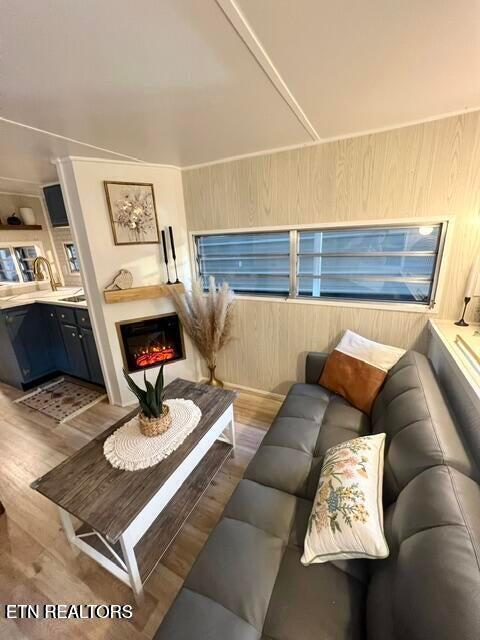 living room featuring light wood-type flooring and wooden walls