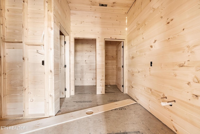 hallway featuring wooden walls