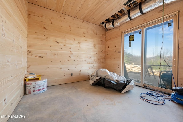 miscellaneous room with wood walls and concrete floors