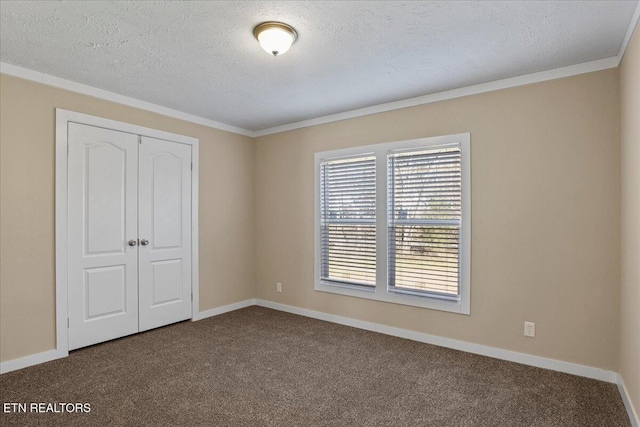 unfurnished bedroom featuring carpet, a textured ceiling, a closet, and crown molding