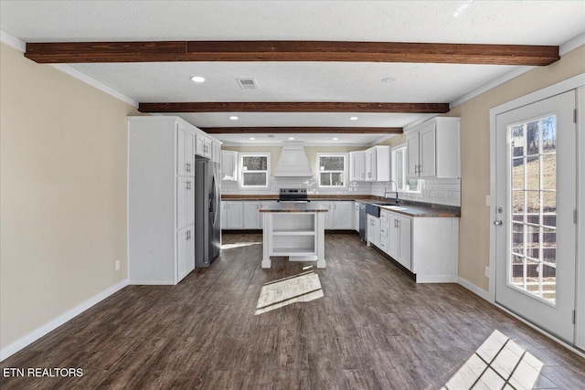 kitchen featuring backsplash, a kitchen island, dark hardwood / wood-style floors, and appliances with stainless steel finishes