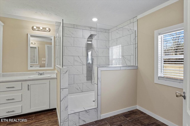 bathroom featuring a textured ceiling, vanity, and shower with separate bathtub