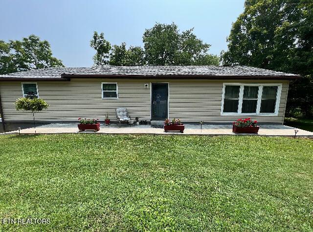 back of property featuring a lawn and a patio