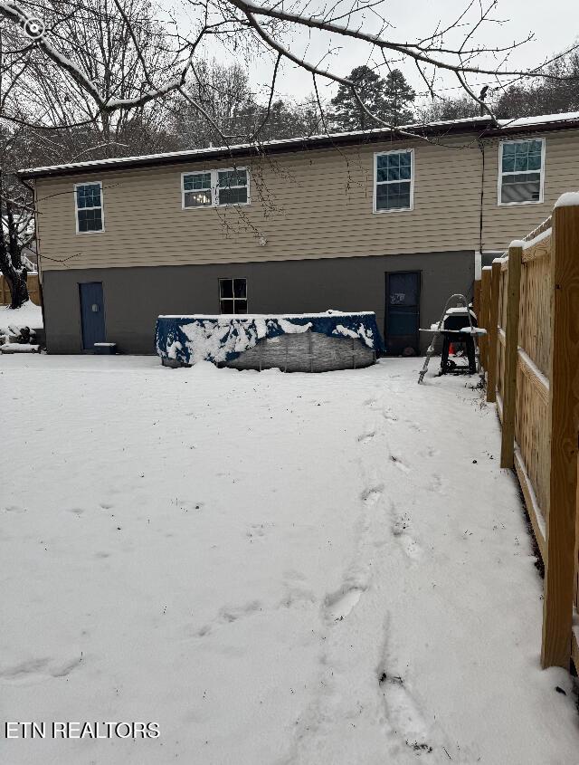 view of snow covered back of property