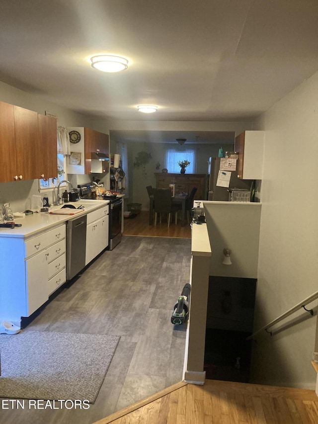 kitchen featuring appliances with stainless steel finishes, sink, light hardwood / wood-style flooring, and white cabinets