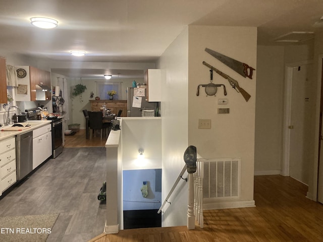 kitchen with stainless steel appliances, light hardwood / wood-style floors, sink, and white cabinets