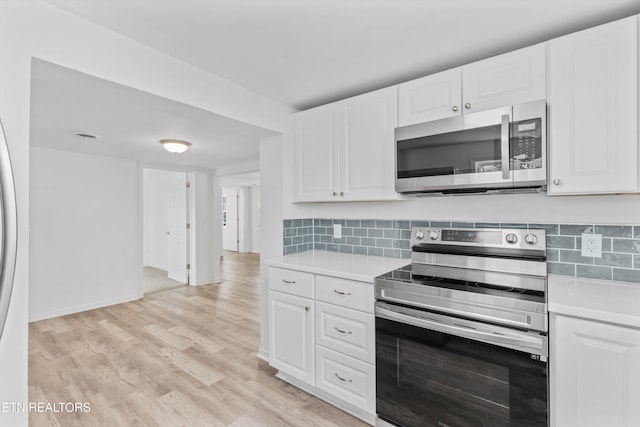 kitchen featuring light wood-type flooring, white cabinetry, and stainless steel appliances