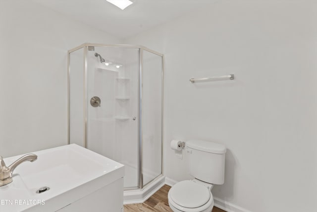 bathroom with hardwood / wood-style flooring, toilet, a shower with shower door, and sink