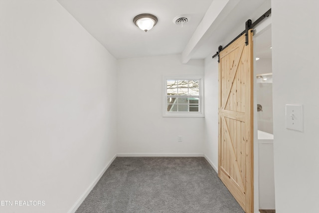 carpeted spare room with a barn door