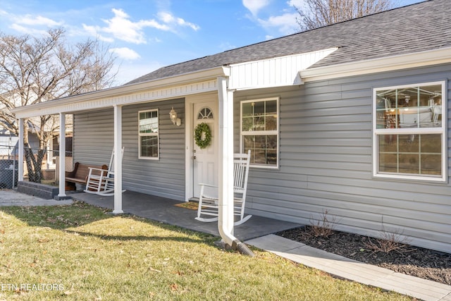 property entrance featuring a porch and a yard