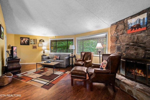 living room featuring hardwood / wood-style flooring, a textured ceiling, and a fireplace