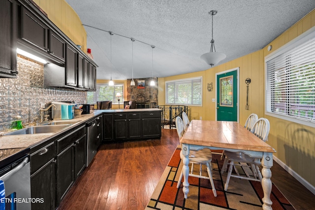 kitchen with plenty of natural light, decorative light fixtures, dark hardwood / wood-style flooring, and sink