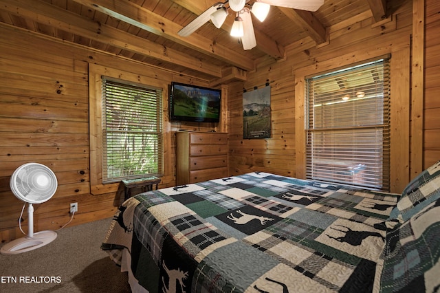 carpeted bedroom featuring beam ceiling, ceiling fan, wood ceiling, and wood walls