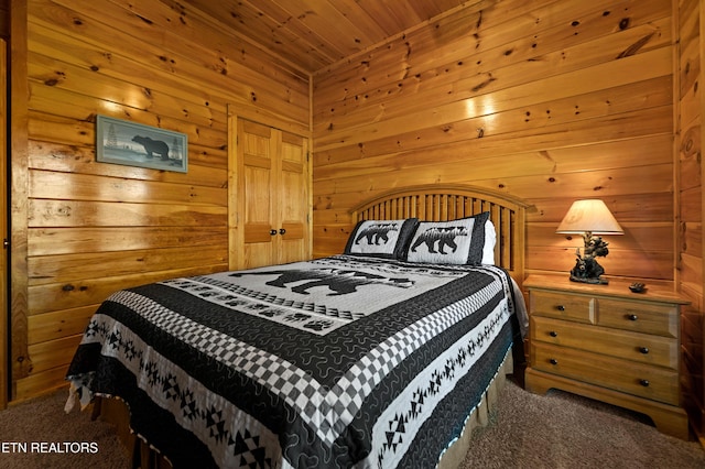 carpeted bedroom with wooden walls and wooden ceiling