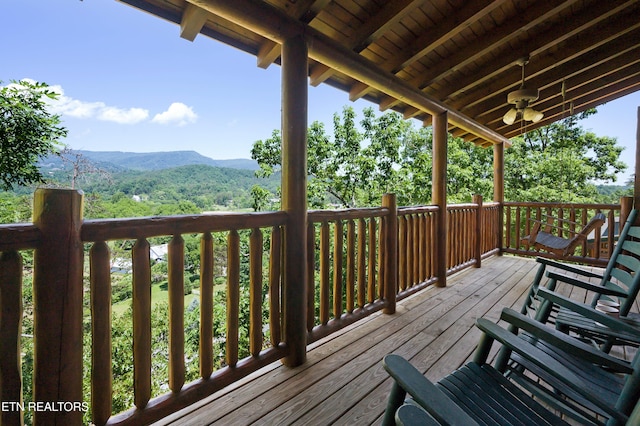 wooden terrace featuring a mountain view and ceiling fan