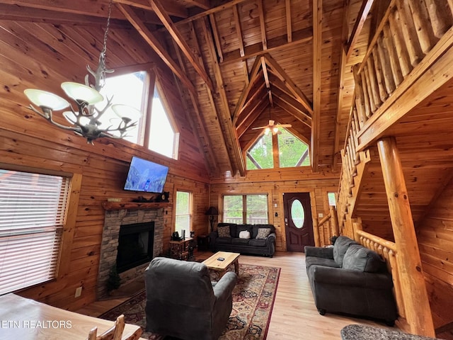 1726 Summit View Way, Pigeon Forge, TN 37862 - living area with wooden walls, high vaulted ceiling, light wood-type flooring, a fireplace, and a chandelier