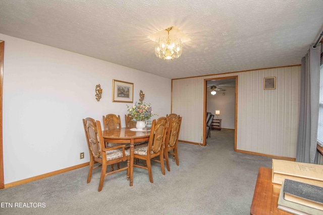 dining area featuring light carpet, a textured ceiling, and a notable chandelier