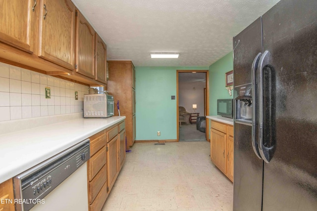 kitchen with decorative backsplash, black appliances, and a textured ceiling