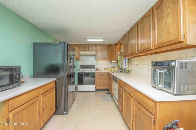 kitchen with black appliances, tasteful backsplash, sink, and a textured ceiling