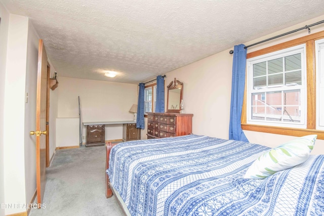 bedroom with light colored carpet and a textured ceiling