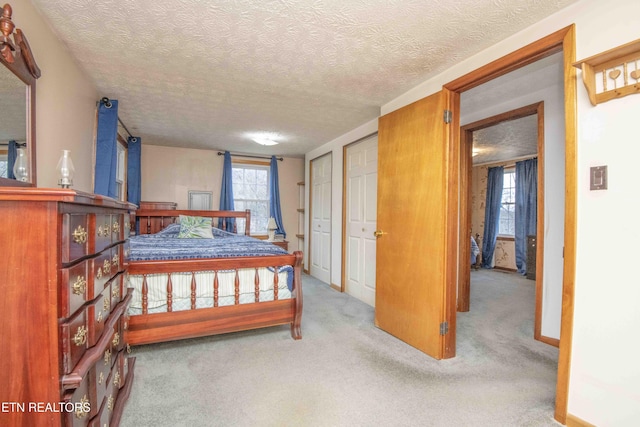 bedroom featuring light carpet and a textured ceiling