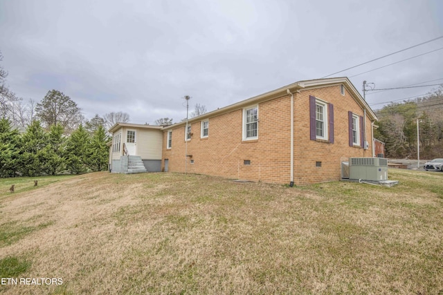 rear view of property featuring central AC unit and a yard