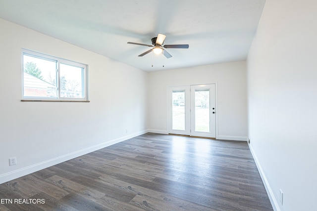 unfurnished room featuring ceiling fan, plenty of natural light, and dark wood-type flooring