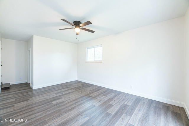 empty room with dark wood-type flooring and ceiling fan