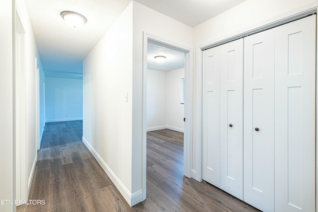 corridor featuring a textured ceiling and dark hardwood / wood-style floors